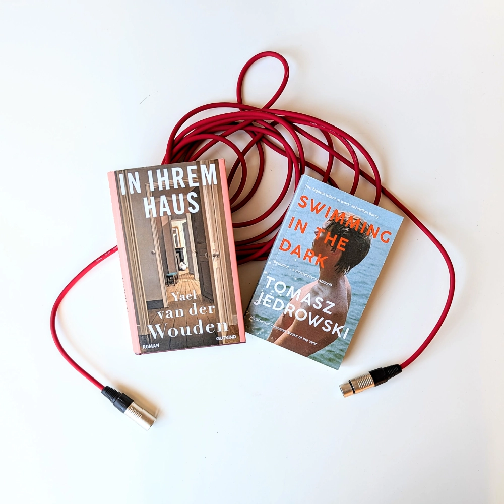Das Foto zeigt die beiden Bücher IN IHREM HAUS von Yael van der Wouden und SWIMMING IN THE DARK von Tomasz Jedrowski.