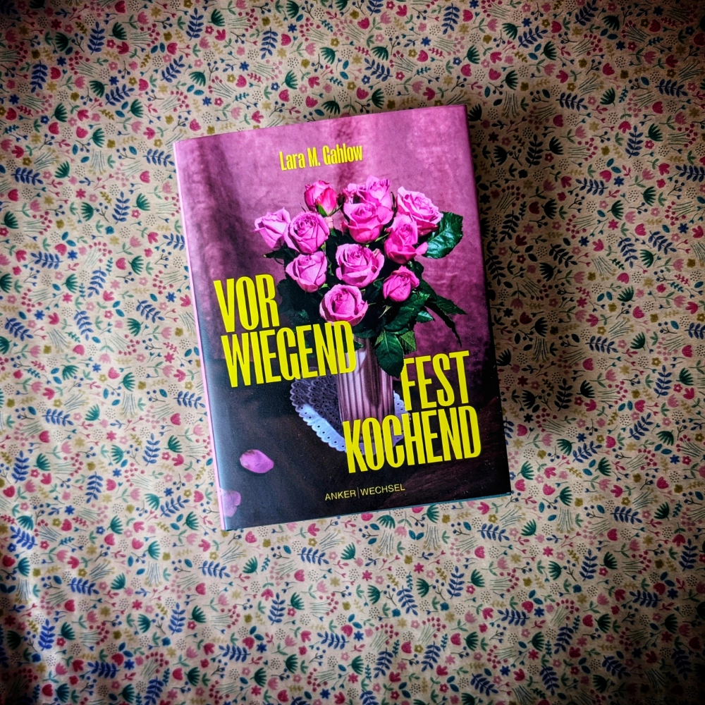 Das Foto zeigt die Hardcover-Ausgabe der Erzählung „Vorwiegend festkochend“ von Laura M. Gahlow, die im Ankerwechsel-Verlag veröffentlicht wurde. Das Buch steht vor einem gemusterten Papier-Hintergrund