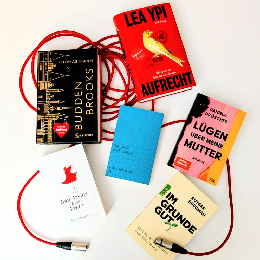 Das Foto zeigt verschiedene Bücher, die im Podcast von Andrea Ludorf vorgestellt werden und im Blog-Text unter dieser Abbildung erwähnt werden; die Bücher liegen auf einem roten Mikrofonkabel.