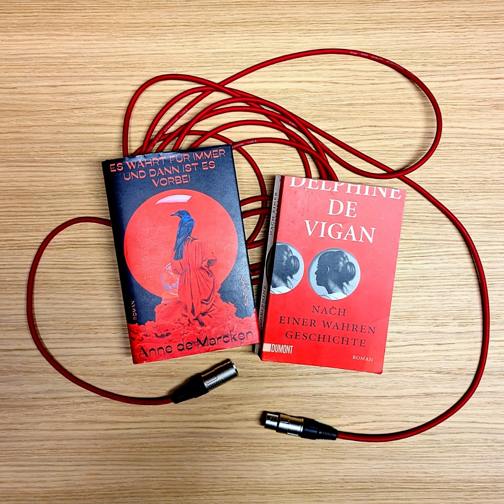 Das Bild zeigt die beiden Bücher 
ES WÄHRT FÜR IMMER UND DANN IST ES VORBEI von Anne de Marcken und NACH EINER WAHREN GESCHICHTE von Delphine de Vigan. Die Bücher liegen auf einem roten Mikrofonkabel.

