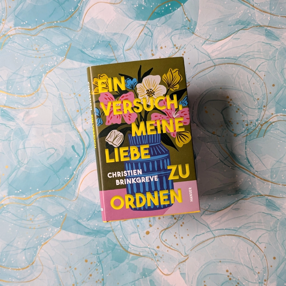 Das Foto zeigt die Hardcover-Ausgabe des Memoirs „Ein Versuch, meine Liebe zu ordnen“ von Christien Brinkgreve, das bei Hanser veröffentlicht wurde. Das Buch liegt auf einem gemusterten Papier-Hintergrund.