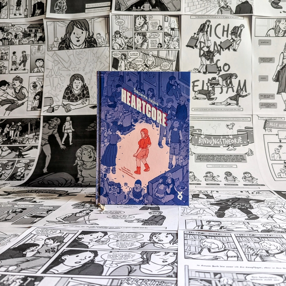Das Foto zeigt die Graphic Novel "Heartcore" von Štěpánka Jislová. Das Buch steht vor einem Hintergrund aus verschiedenen, zusammengeklebten Seiten aus dem Buch.
