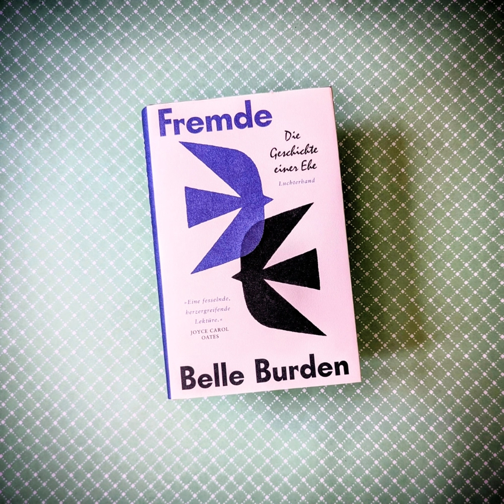 Das Foto zeigt das Buch "Fremde" von Belle Burden, das in der Übersetzung von Charlotte Breuer bei Luchterhand erschienen ist; es liegt auf einem gemusterten Papierhintergrund.