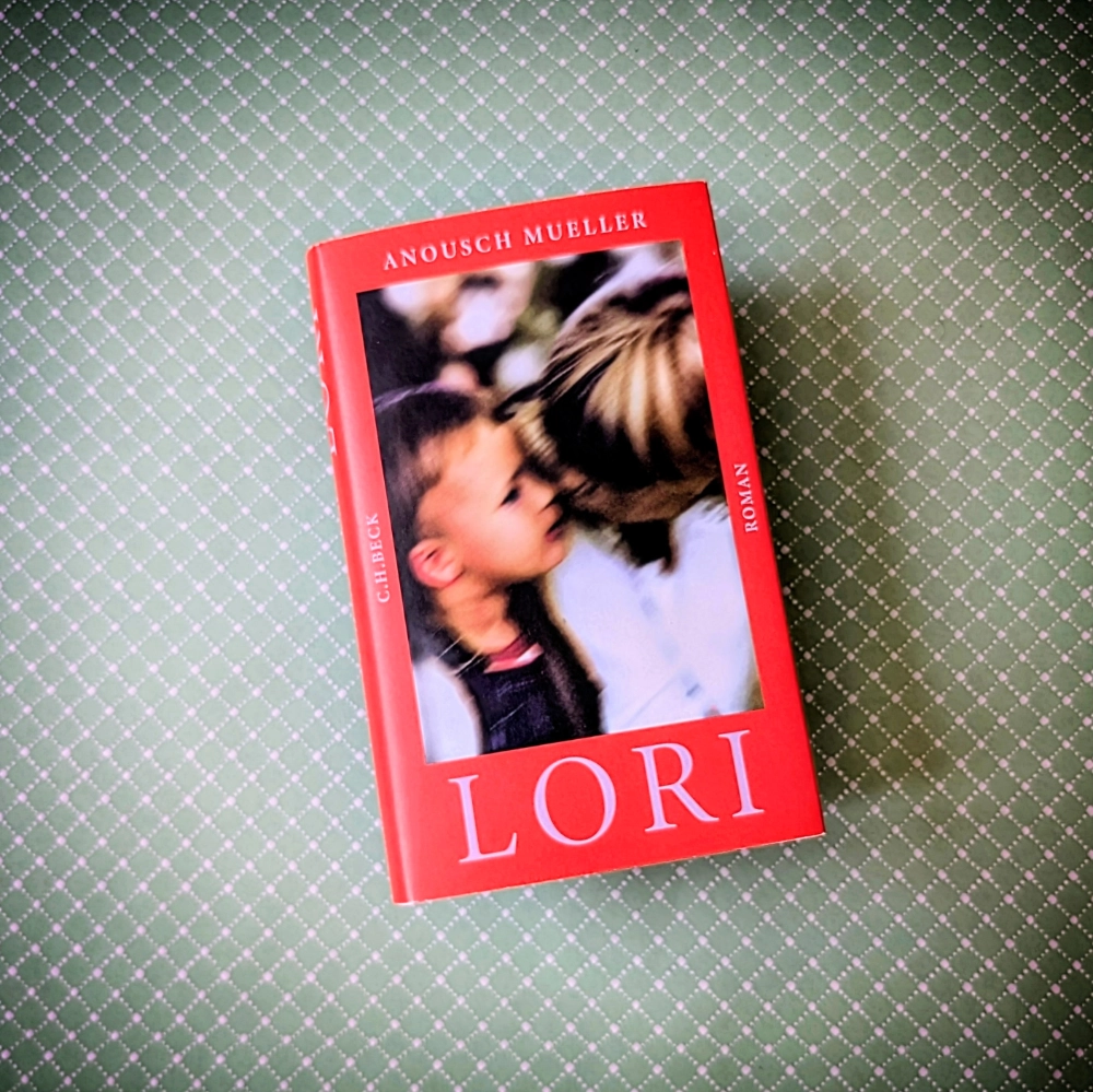 Das Foto zeigt das Buch "Lori" von Anousch Mueller, das im Verlag C.H. Beck erschienen ist; es liegt auf einem gemusterten Papierhintergrund.
